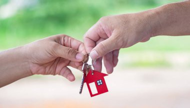 Emlakçı ev sahibine anahtarları veriyor.