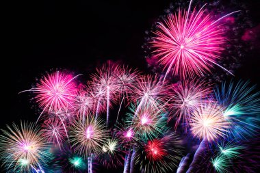 Gece gökyüzü arka planında renkli havai fişekler.