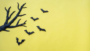 Sarı zemin üzerinde ağaç olan Cadılar Bayramı yarasaları, kopyalama alanı olan Cadılar Bayramı arka planı.