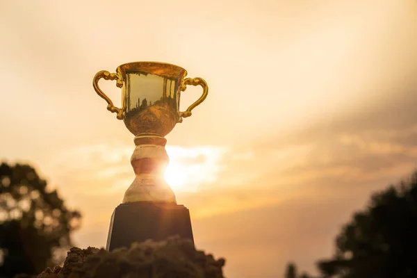 勝利のコンセプト 日の出の空の背景を持つ上の山の金のトロフィーカップ — ストック写真