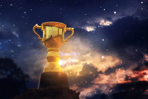 Win concept,Gold trophy cup on top mountain with sunrise sky background.