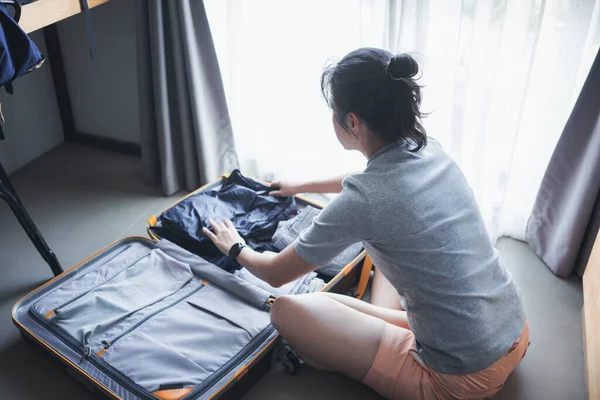 Woman packing clothes into packing a luggage for a new journey, summer vacation, travel, concept