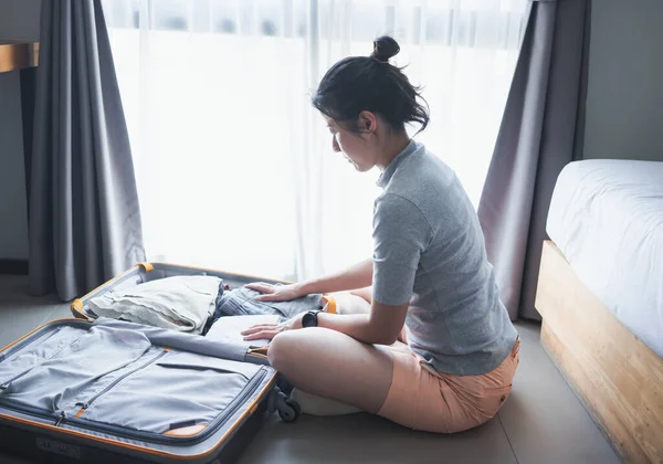 Woman packing clothes into packing a luggage for a new journey, summer vacation, travel, concept