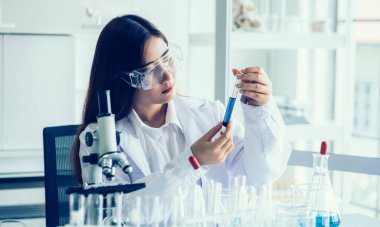 Laboratuvar araştırması için elinde test tüpleri tutan bir bilim adamı..