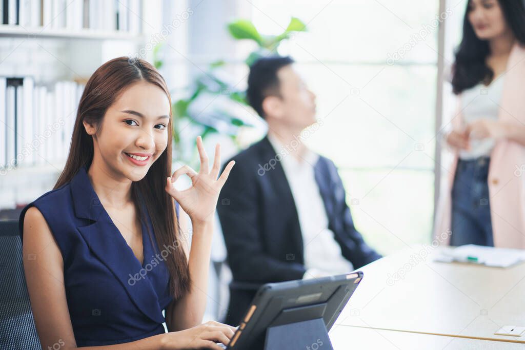 Portrait of young business woman showing ok sign,Looking at the camera with showing success