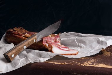 Pastırma füme ve bıçak ambalaj kağıt üzerinde şişir. Vintage natu