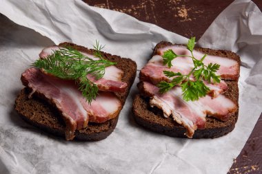 Siyah çavdar ekmeği üzerinde beyaz packagi ile pastırma füme dilimleri