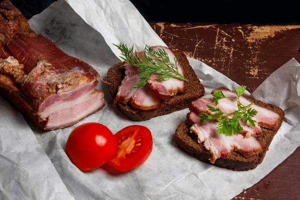 Bacon defumado com pão preto de centeio e tomates cortados na embalagem — Fotografia de Stock