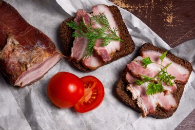 Füme pastırma çavdar ile siyah ekmek ve cuted domates üzerinde paketi