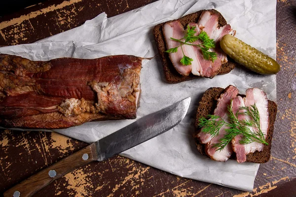 Gerookt spek met zwarte roggebrood en verschillende augurken op de pac — Stockfoto