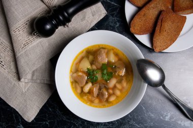 Metal kaşık, whit birkaç tost ile beyaz tabak fasulye çorbası