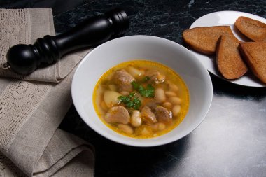 Beyaz plaka, beyaz bir blac tabağa birkaç tost fasulye çorbası