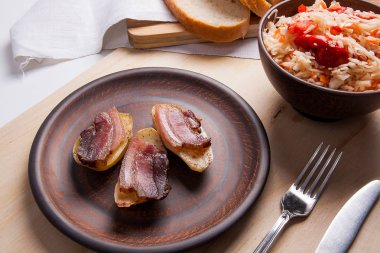 Dilim pastırma ve mutfak eşyaları woode üzerinde yemek fırında patates