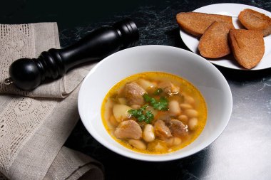 Beyaz plaka, beyaz bir blac tabağa birkaç tost fasulye çorbası