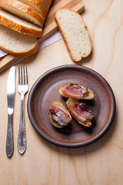 Ahşap zemin üzerine pastırma dilimlerini fırında patates. Dilimleri