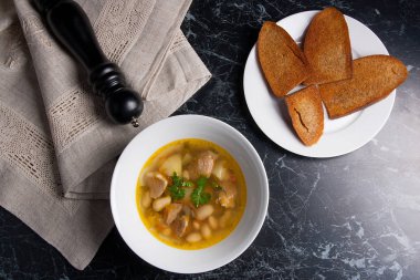 Beyaz plaka, beyaz bir blac tabağa birkaç tost fasulye çorbası