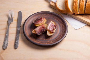 Ahşap zemin üzerine pastırma dilimlerini fırında patates. Dilimleri