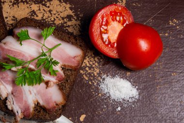 Füme pastırma çavdar ile siyah ekmek ve cuted domates üzerinde paketi