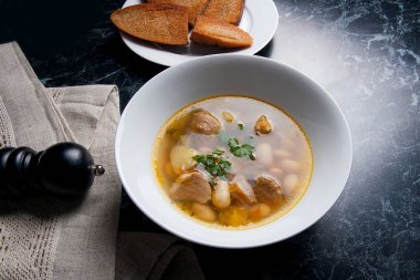 Beyaz plaka, beyaz bir blac tabağa birkaç tost fasulye çorbası