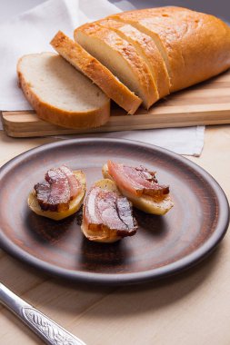 Ahşap zemin üzerine pastırma dilimlerini fırında patates. Dilimleri