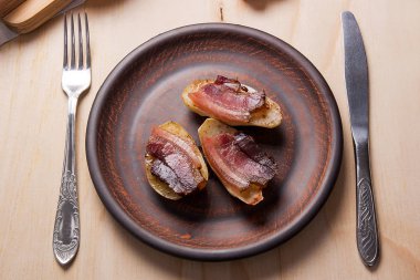 Ahşap zemin üzerine pastırma dilimlerini fırında patates. Dilimleri