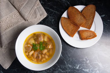 Beyaz plaka, beyaz bir blac tabağa birkaç tost fasulye çorbası