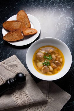 Beyaz plaka, beyaz bir blac tabağa birkaç tost fasulye çorbası