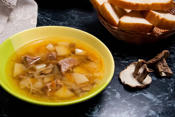 Zupa grzybowa w zielony talerz, suszone grzyby i kosz — Zdjęcie stockowe