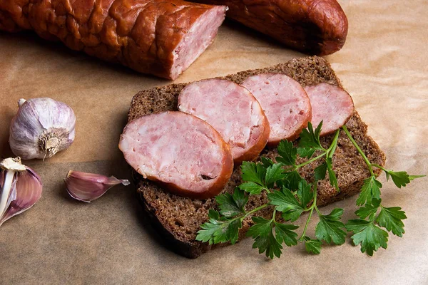 Slices of smoked sausage with spice, herbs and vegetables on the