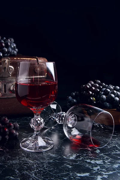 Sklenice červeného vína na tmavě béžové pozadí. Shluk modré gra — Stock fotografie