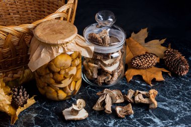 İki Cam Kavanoz siyah mermer zemin üzerine yabani mantar ile.