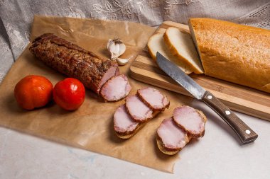 Füme dilimleri et ya da jambon ve kahverengi ambalaj kağıt üzerinde bıçak. Toma