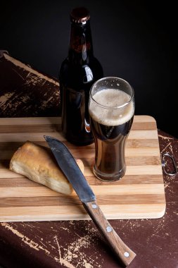 Cam ve kesme domuz üzerinde füme peynir ile koyu bira şişe