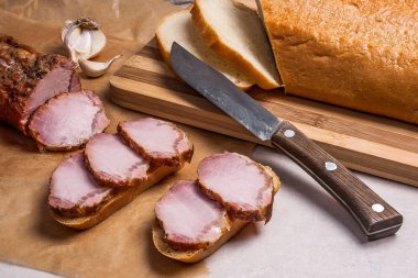 Füme dilimleri et ya da jambon ve kahverengi ambalaj kağıt üzerinde bıçak. Toma