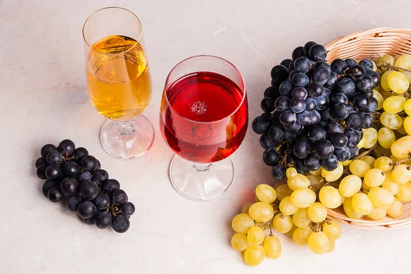 Вино и виноград. Белое и красное вино в стаканах из светлого мрамора b — стоковое фото