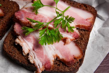 Siyah çavdar ekmeği üzerinde beyaz packagi ile pastırma füme dilimleri