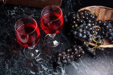 Karanlık mermer zemin üzerine kırmızı şarap bir bardak. Küme mavi GRA