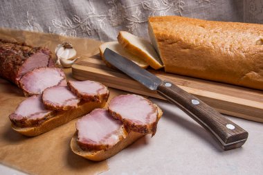 Füme dilimleri et ya da jambon ve kahverengi ambalaj kağıt üzerinde bıçak. Toma