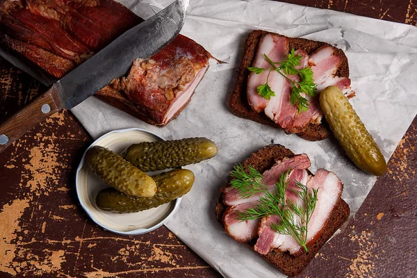 Gerookt spek met zwarte roggebrood en verschillende augurken op de pac — Stockfoto