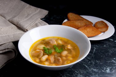 Beyaz plaka, beyaz bir blac tabağa birkaç tost fasulye çorbası