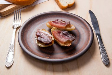 Ahşap zemin üzerine pastırma dilimlerini fırında patates. Dilimleri