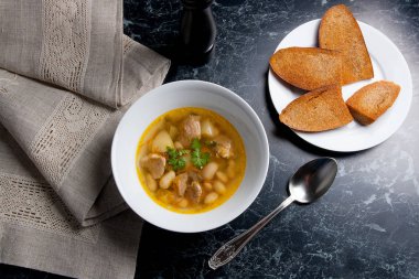 Metal kaşık, whit birkaç tost ile beyaz tabak fasulye çorbası