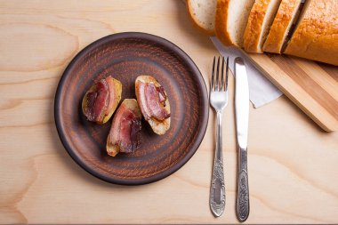 Ahşap zemin üzerine pastırma dilimlerini fırında patates. Dilimleri