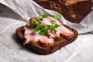 Siyah çavdar ekmeği üzerinde beyaz packagi ile pastırma füme dilimleri