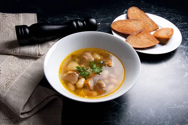 Beyaz plaka, beyaz bir blac tabağa birkaç tost fasulye çorbası