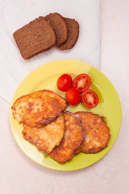 İle et ve domates ile çavdar b yeşil plaka üzerinde patates pancakes