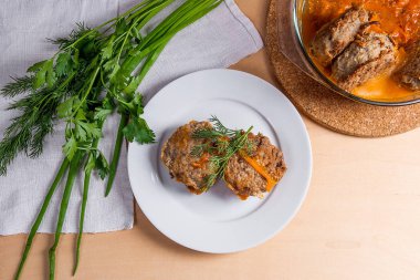 Beyaz bir tabak ve otlar - dereotu, yeşil servis domuz eti köfte 