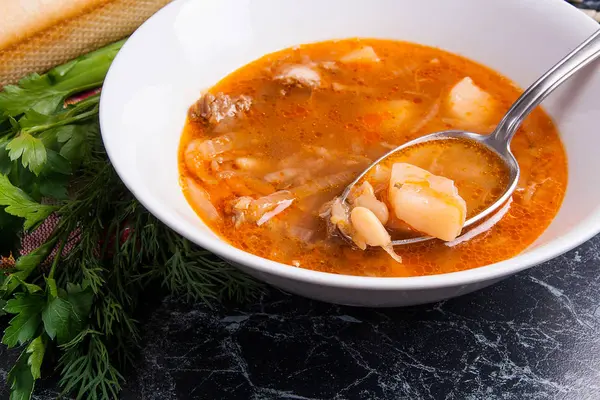 Закрыть вид на тарелку и ложку супом из красного жука или борщом — стоковое фото