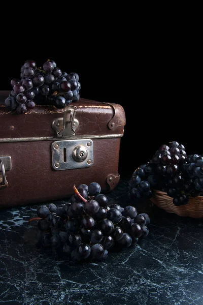 Cluster of blue grapes on dark marble background. Vintage case o — Stock Photo, Image