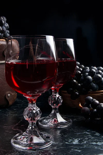 Copa de vino tinto sobre fondo de mármol oscuro. Racimo de gra azul — Foto de Stock